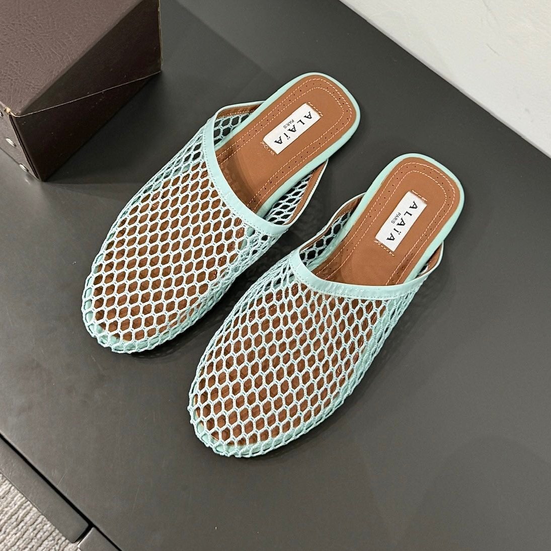 ALAIA FLAT MULES IN LIGHT BLUE MESH FISHNET
