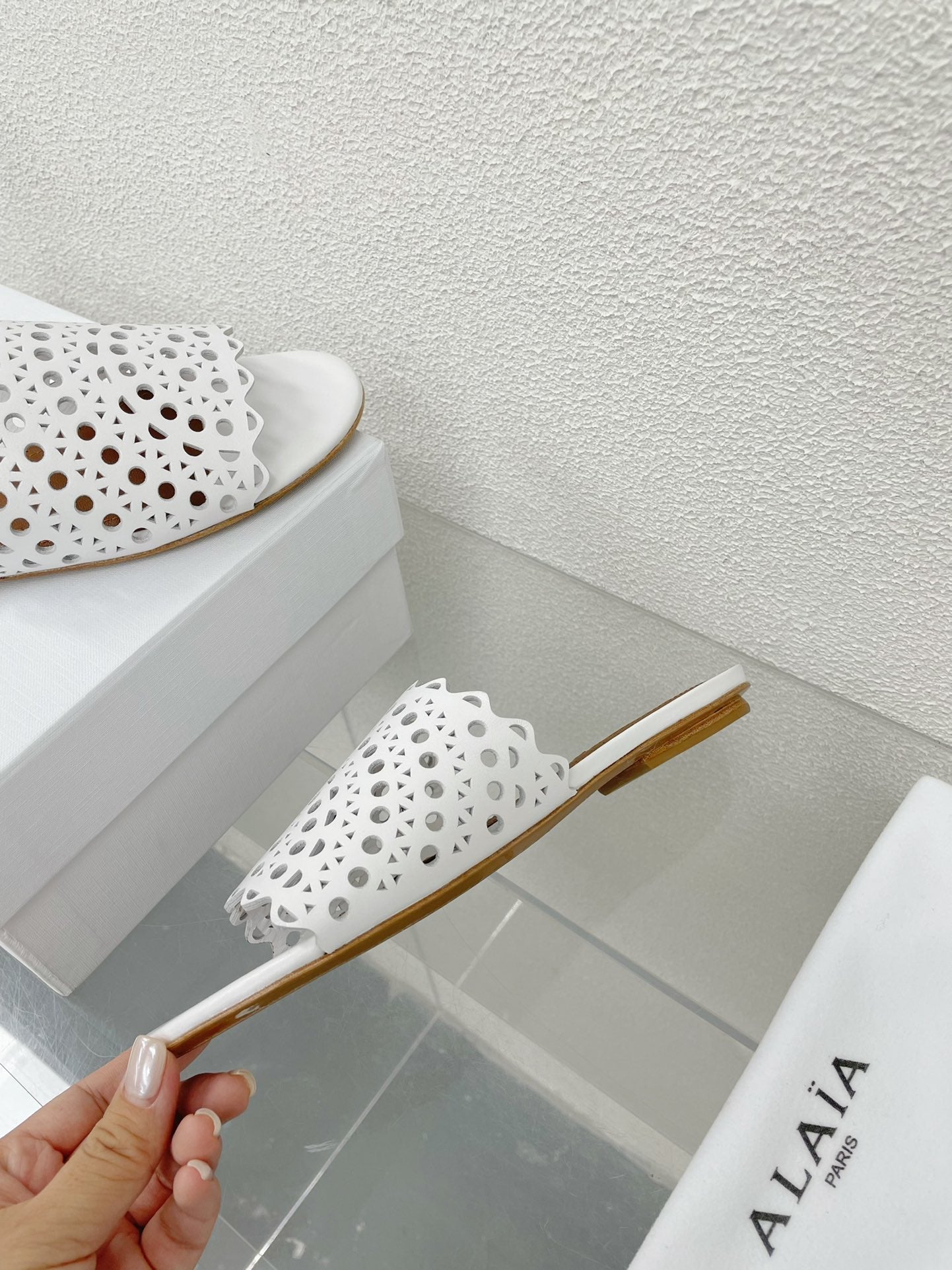 ALAIA VIENNE FLAT MULES IN WHITE LAMBSKIN
